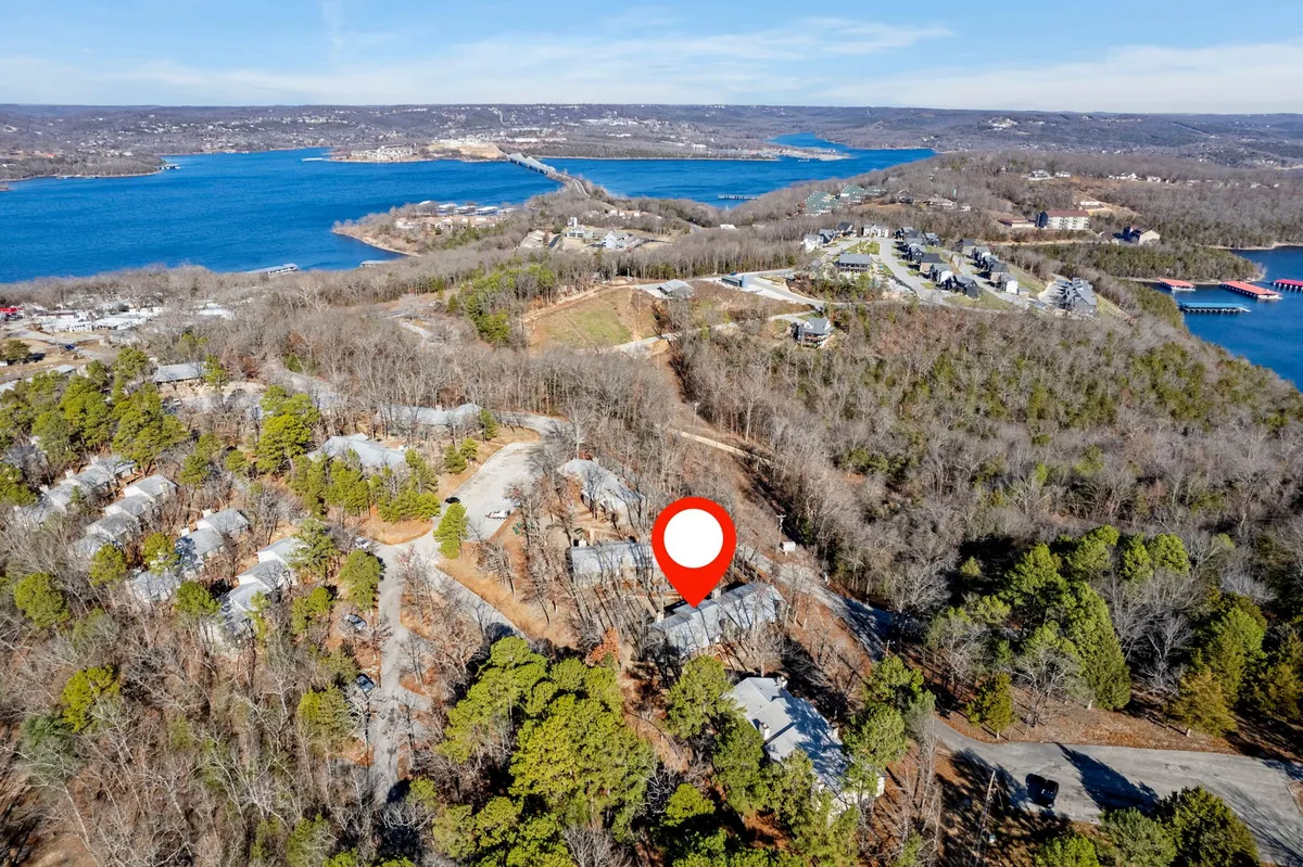 A peaceful exterior shot capturing a picturesque waterfront with a cluster of buildings nestled in nature. The calm water, soft light, and natural landscape invite exploration and relaxation. Wildlife observation and sunset views are implied by the tranquil scene.